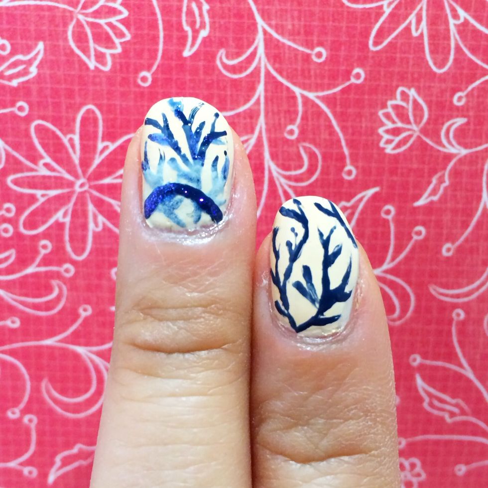 With a thin nail art brush, dip it into a dark blue polish. Starting from anywhere in the bottom, create several thick crooked lines. Then from there add more line to create varying size branches.