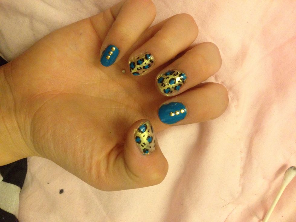 With a tooth pick dipped in black nail polish (or a black nail art pen) draw little half circles around the blue blobs