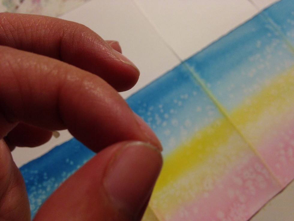 with a wet brush and the paper with a color at a time to create three horizontal color stripes take a pinch of salt and lascatelo fall randomly on the still wet color