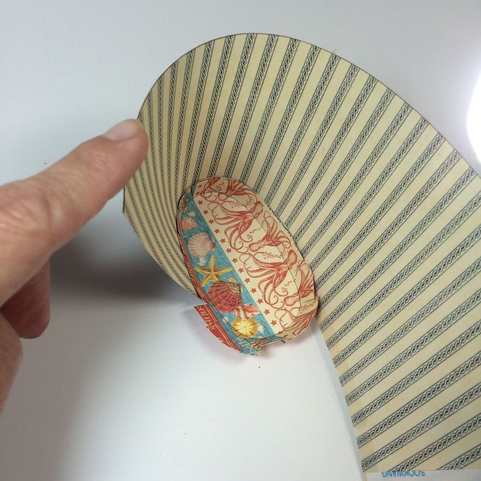 With base piece on table, start rolling the main piece around it as shown.