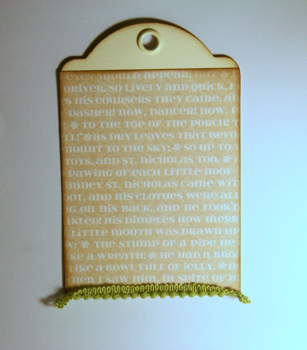 With hot glue attach pom pom trim to bottom of tag.