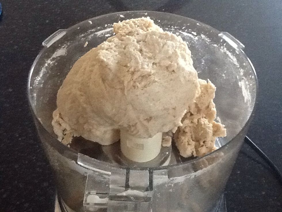 With machine running, slowly pour in warm water. Once water is added, continue processing until dough comes together into a ball, around 30-45 seconds.