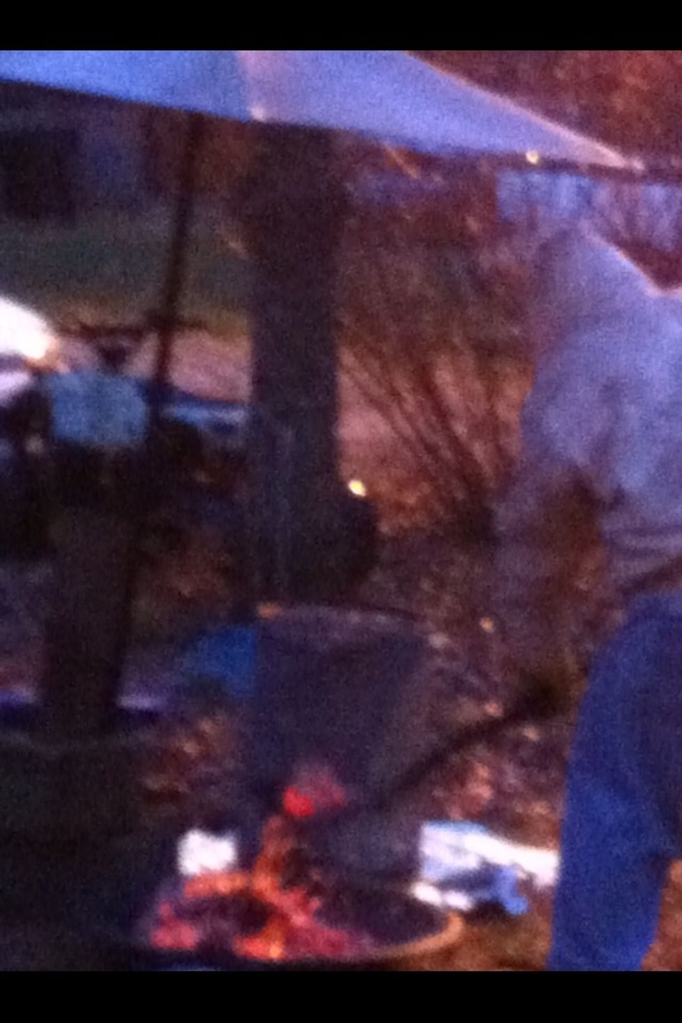 With metal shovel, place prepared charcoal all around bottom edge of can.
