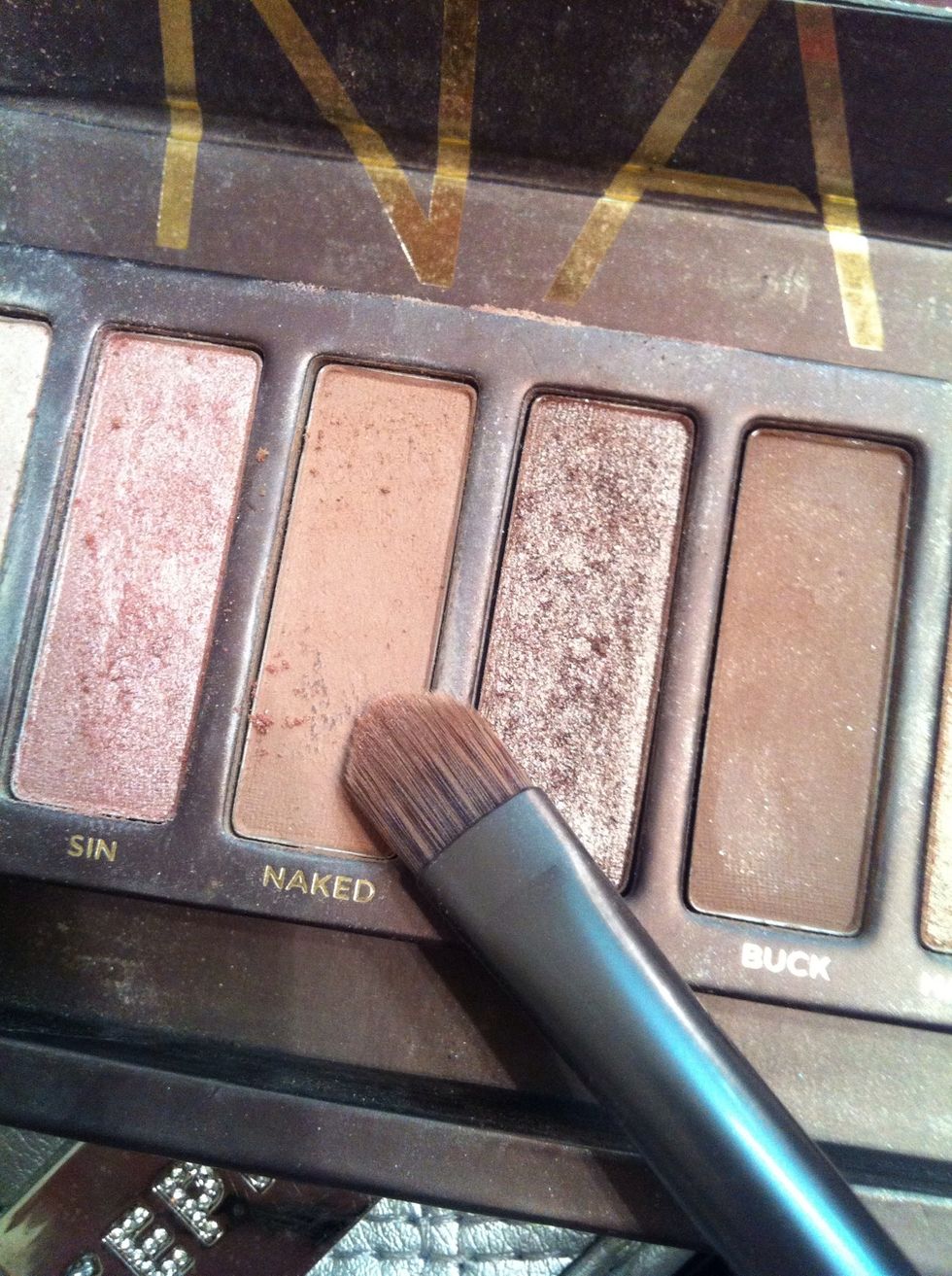 With my shadow brush next I am applying the color naked in the urban decay palate "naked." I will apply this color across my lid. Any neutral color will work similar to this.