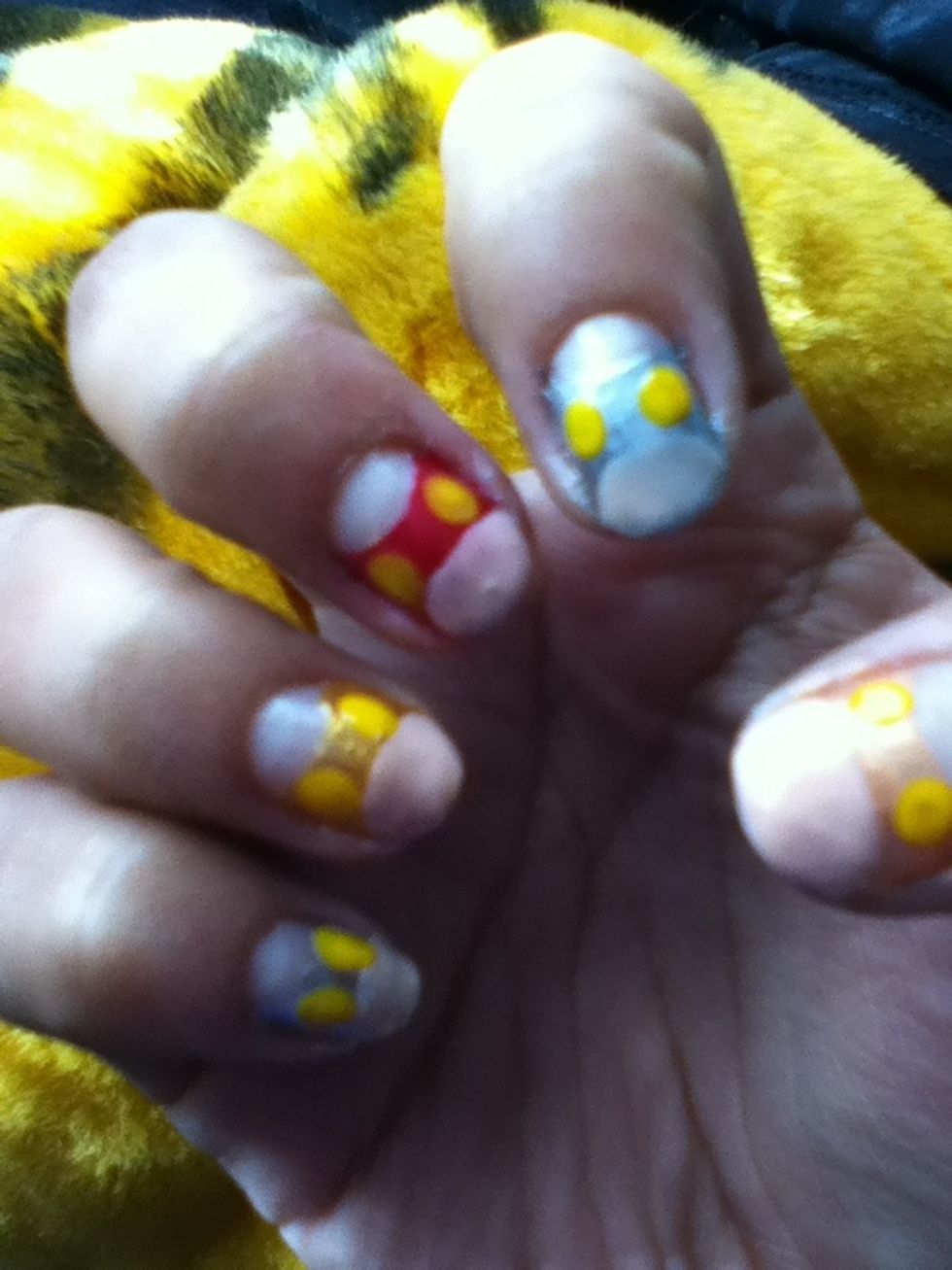 With nude or pallid pink nail polish make a circle in the tips to create a belly, after that use a dotting tool and yellow nail polish and make two circles for the eyes