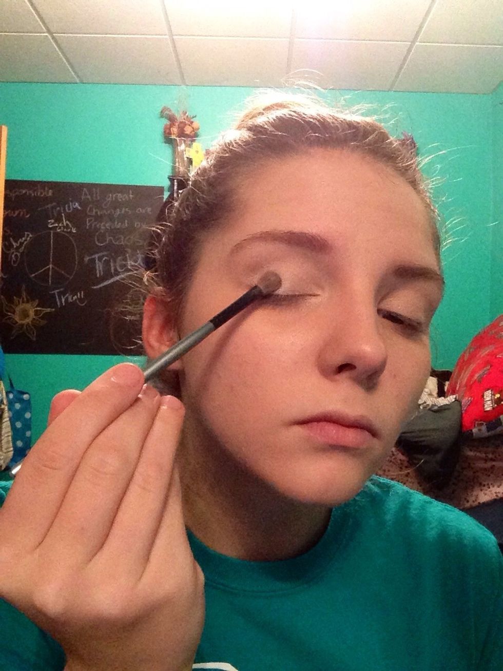 With one of the eyeshadow brushes, brush a fair amount of the lightest shadow from the inner corner of your eyelid across the entire lid. Also brush a dab under the arch of your eyebrow.