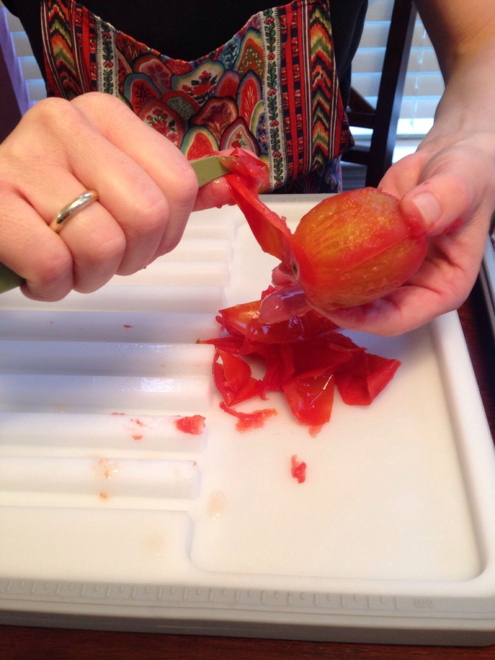 With paring knife, gently remove skin from the cooked tomatoes. Be sure to remove core as well.