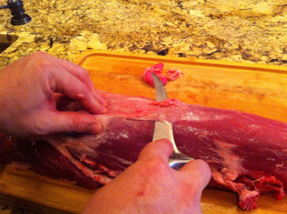 With the blade of your knife angled slightly upwards, slide it along the underside of the membrane until it separates from the loin.