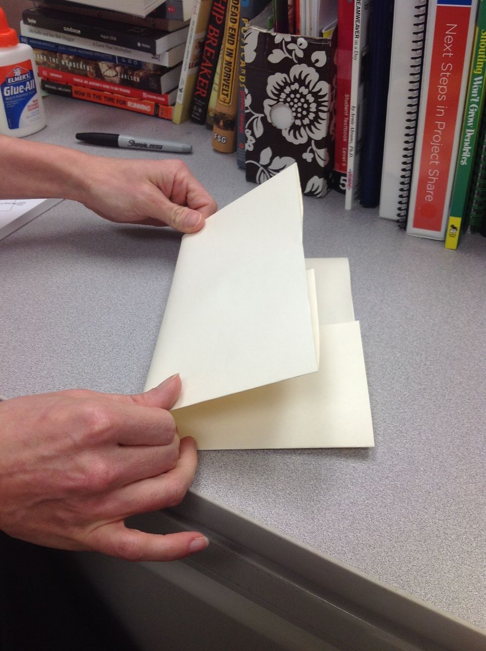 With the edges folded in to the center, fold the paper in half like a hamburger.