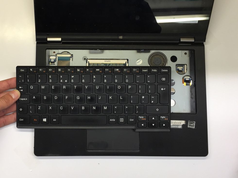 With the keyboard lifted from the chassis, sit the computer down in the normal operating position as shown. Lift the keyboard and move it down and to the left.