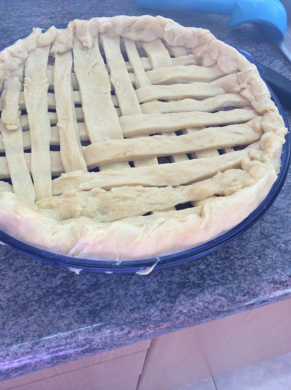 With the left over pastry, roll it out and then cut it into long strips and make a criss- cross pattern on the top of your dish to make a lid for the apple pie. Then fold the access pastry inwards.