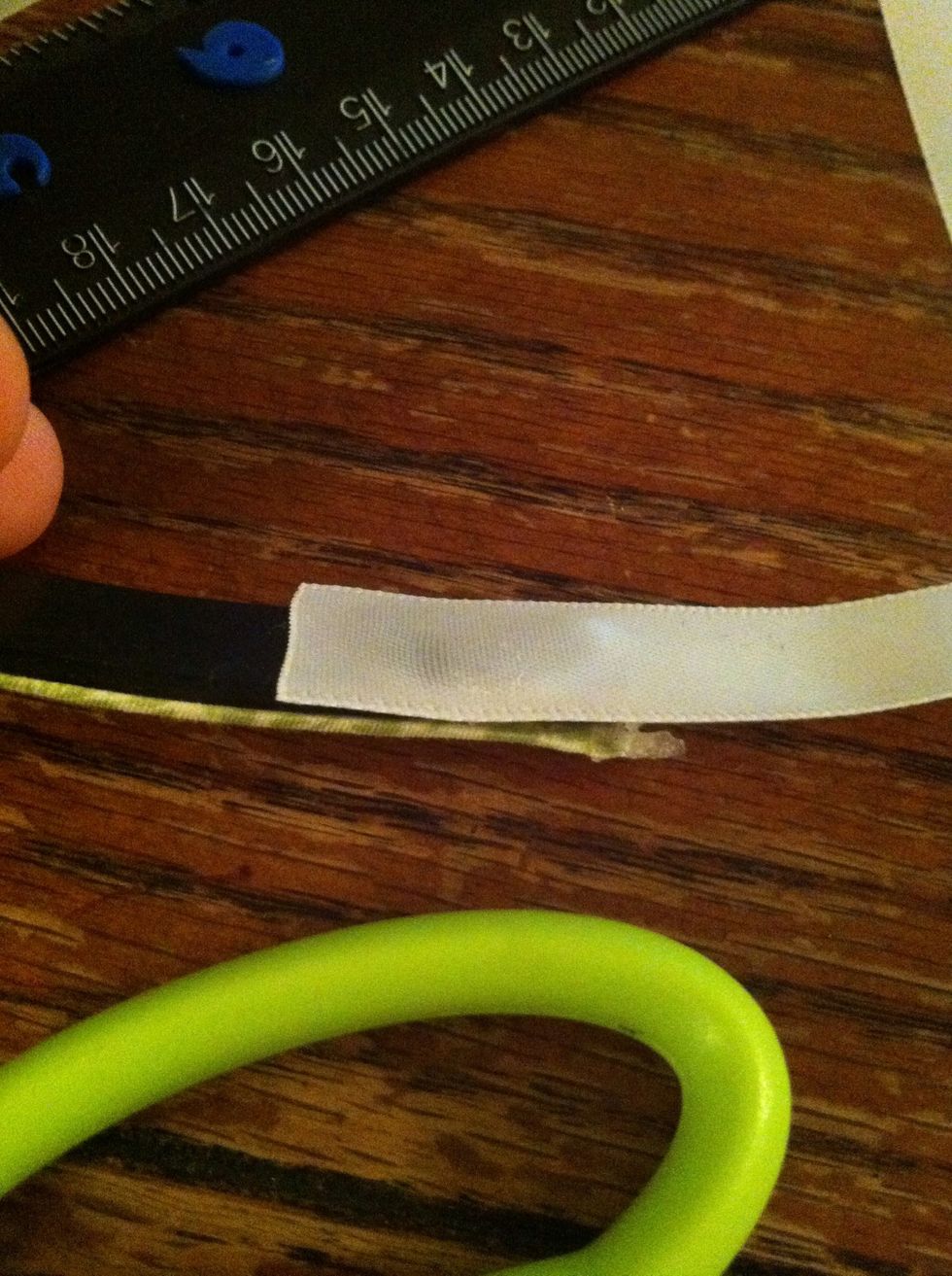 With the longer piece of ribbon, place a dot of hot glue on the inside of the headband and secure a short end of ribbon.