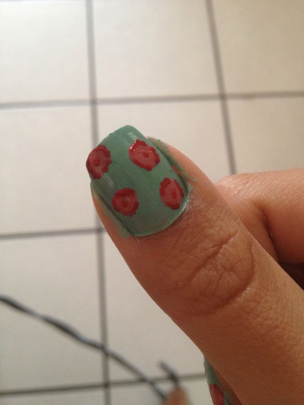 With the red nail polish draw the dots circumference and put a small dot in the middle