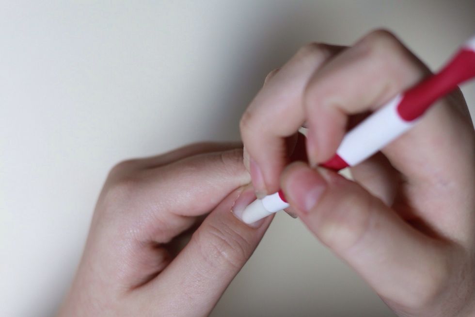 With the rubber side of the stick, you are going to push back your cuticles.