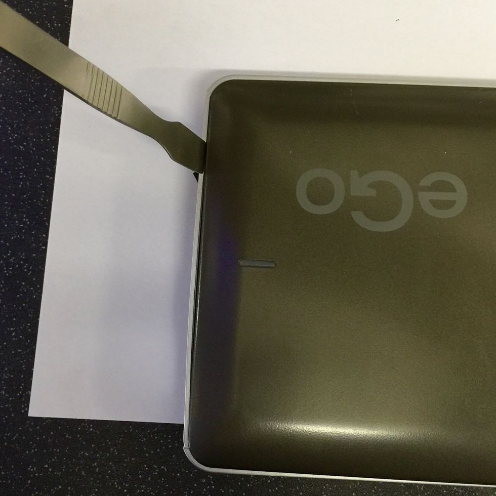 With the screws from the previous step secured and labelled turn the drive over and insert your spudger between the top panel and side by the power switch in exactly the same we we removed the bottom.