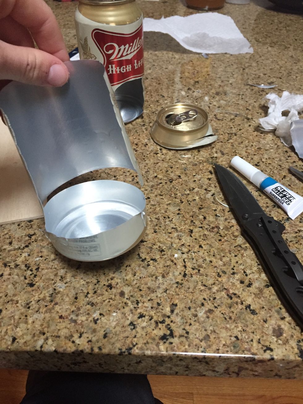 With the second can cut a long strip off the face of the can