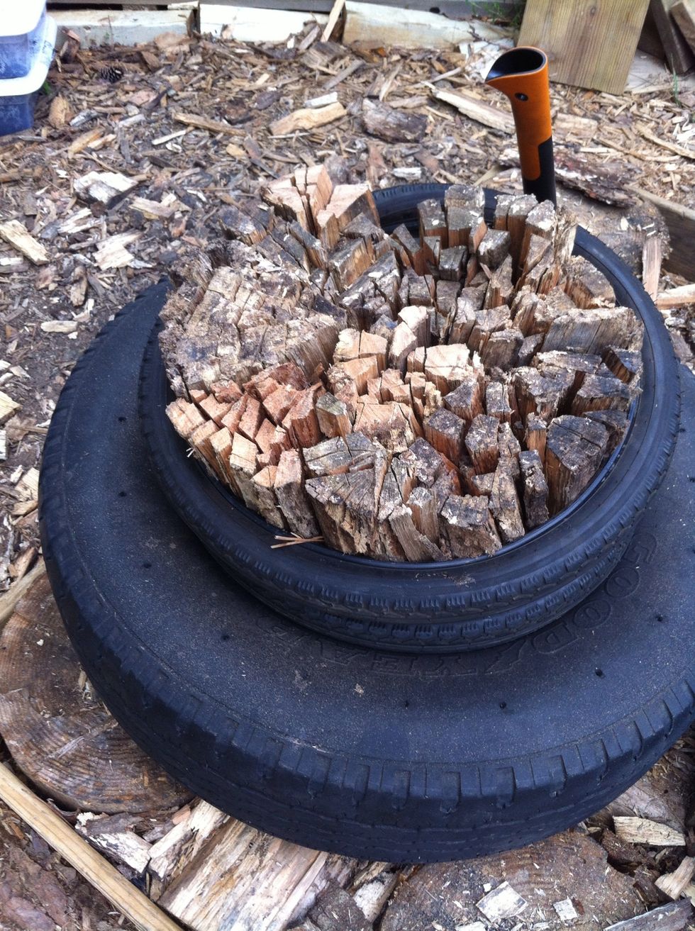 With the splitting ax (Fiskars), split the pieces into no larger than 1" across, then lift the wood bundle up with the bike tires, flip over, and do the same to the other side. Avoid chopping tires.