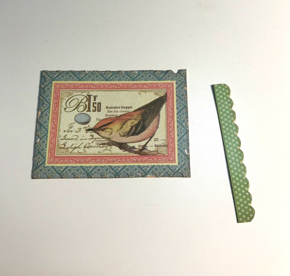 With the sticker sheet still out, adhere the postage stamp and scallop border to another piece of scrap paper. Fussy cut the images out. Ink the edges of the images using Vintage Photo Distress Ink.