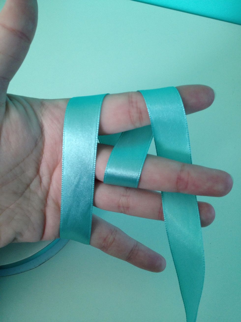 With the strand you just weaved, wrap it over your first finger and under your second. It's the reversed procedure of Step 4.