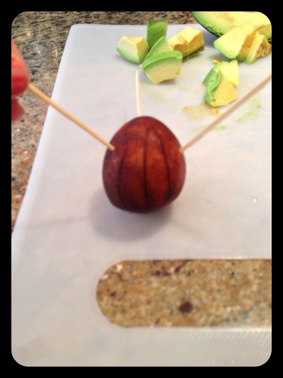 With the wide end of the pit facing down, press in 3 or more toothpicks.