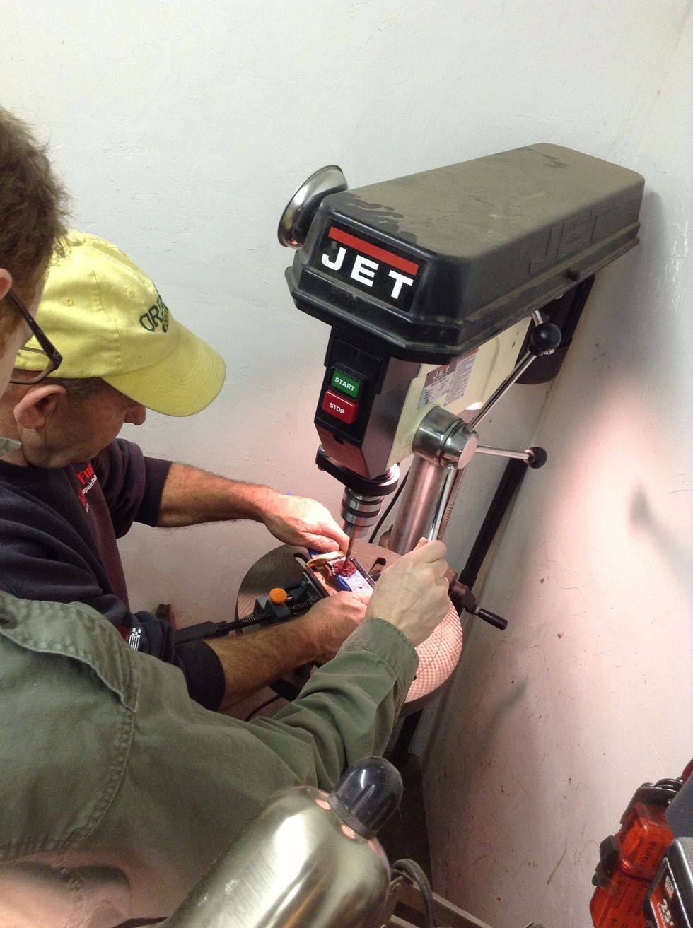 With the wood side down, drill through the pin holes. Taping is a good idea, so the handle pieces don't move around. Remember, safety third - always wear eye protection. Right, Dad?