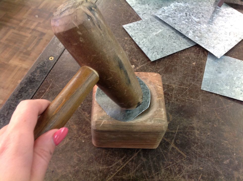 With the wooden mould, place the sheet metal over the rounded part and start hammering with the tinmans mallet. The metal should start to divot and shape....