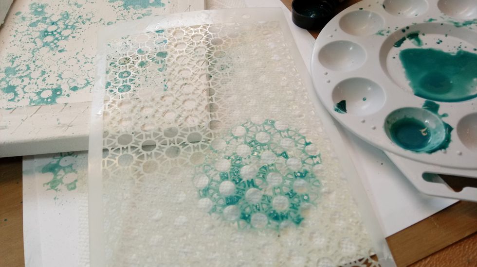 With watered down paint, i dabbed it on my stencil and pressed it down on the canvas. It comes out kind of like a messy stamped image.