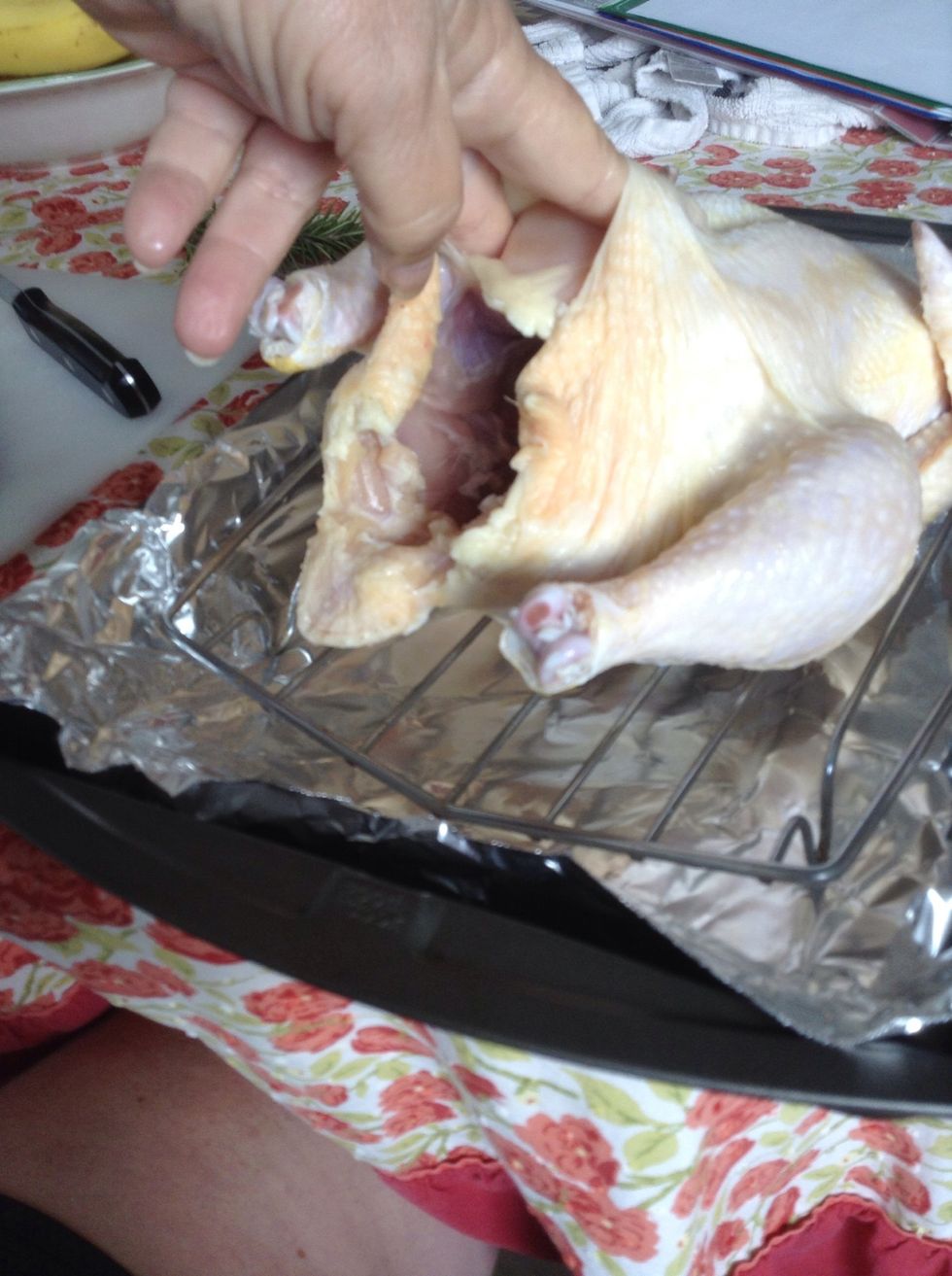 With your fingers separate the skin of the chicken from the meat. We're going to be putting some of our ingredients directly in here.