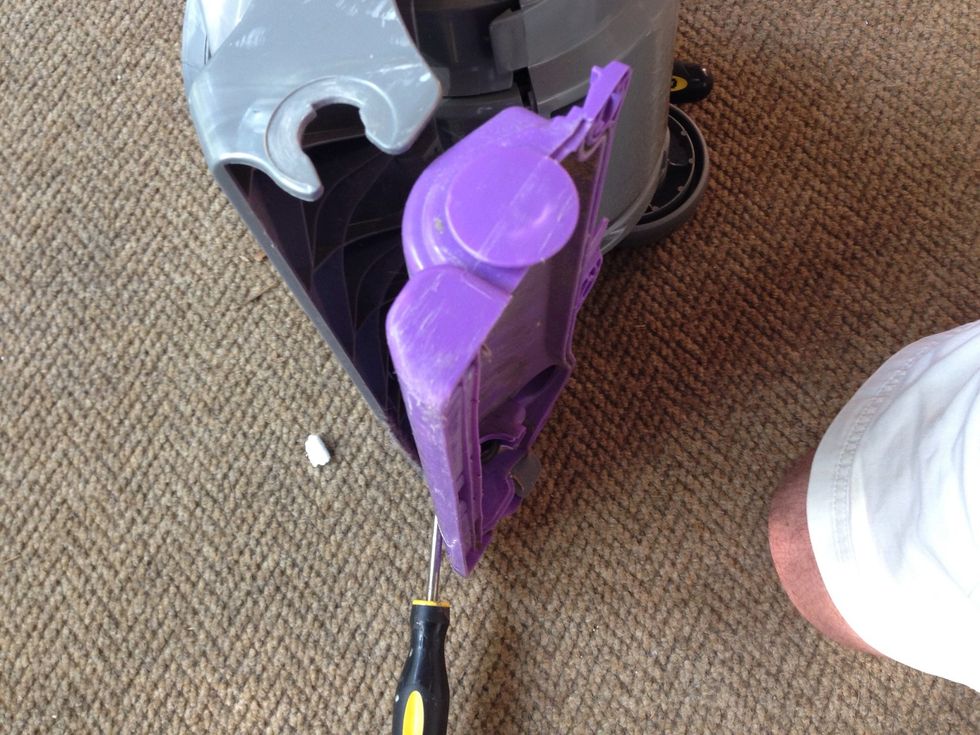 With your flathead screwdriver inserted between the purple plastic howling and the gray body of the vacuum snap that cowling out prying on both sides evenly