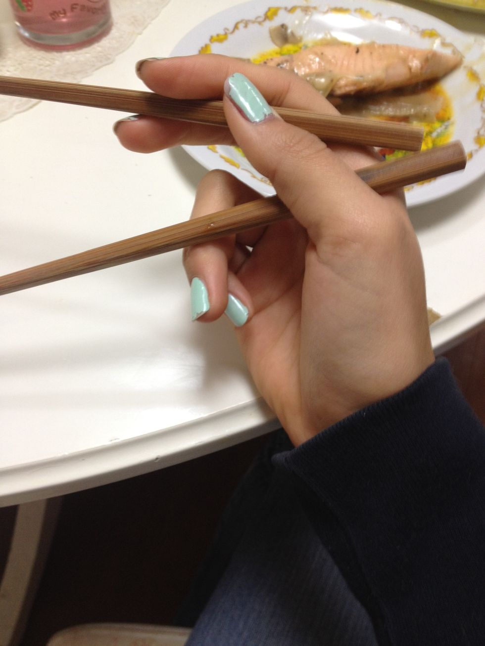 With your index and middle finger you can move your upper chopstick up and down and keep the lower one still