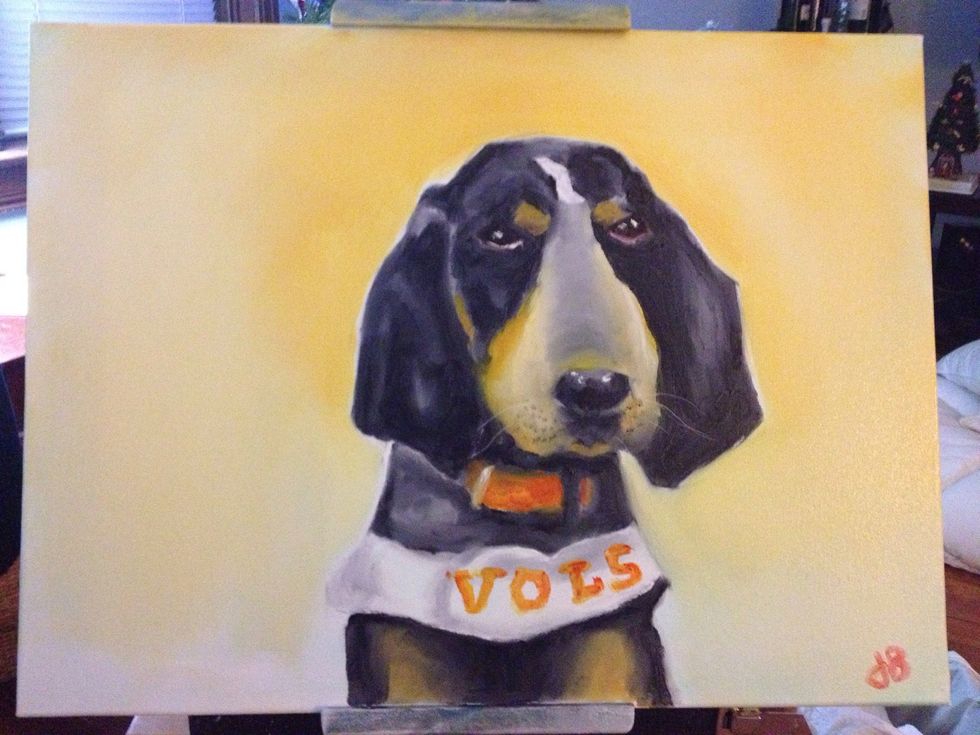 With your large chip brush, take a light colored orange and blend a background around Smokey.with your pinky, use the orange to write Vols on his uniform.
