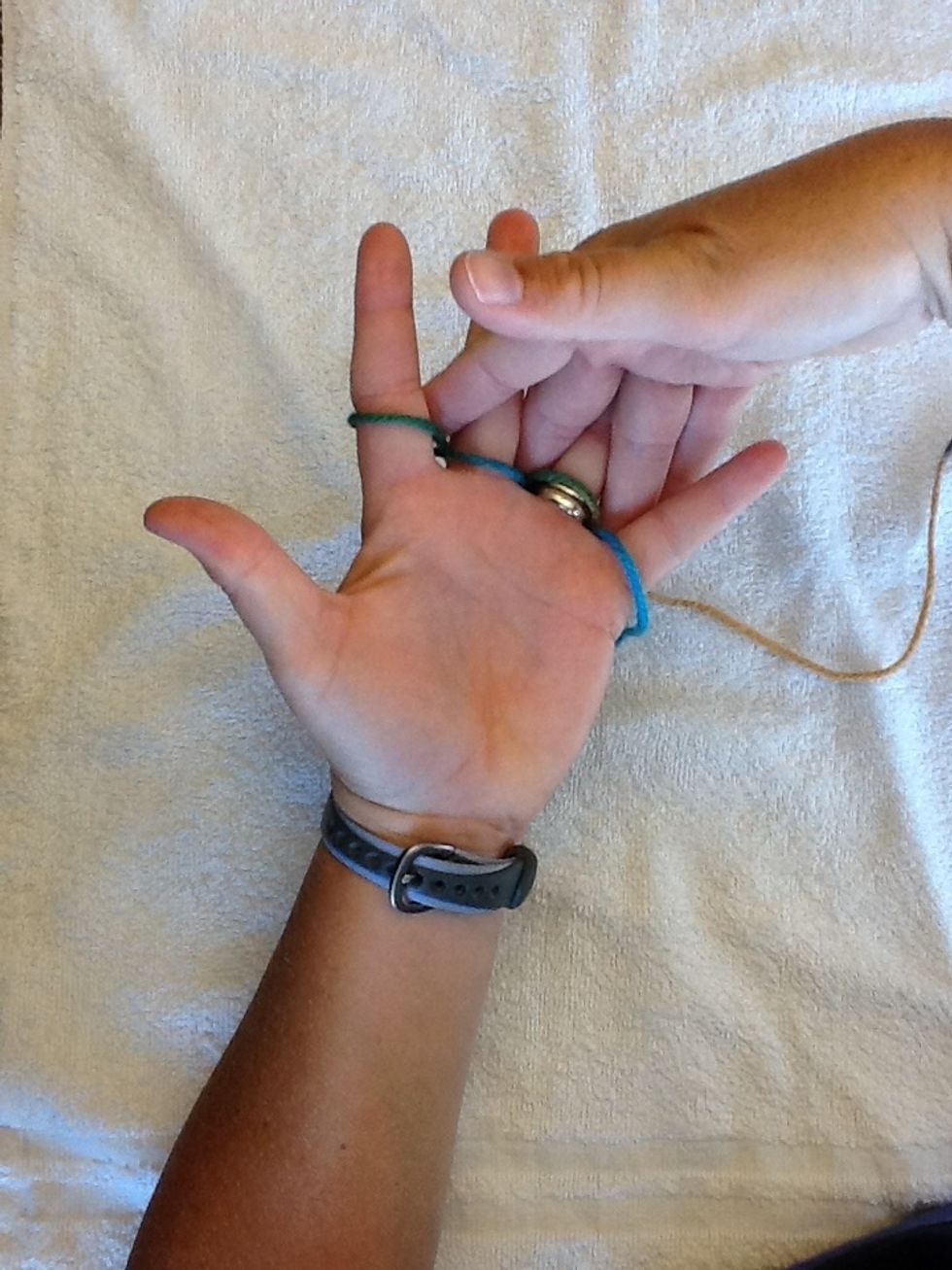 With your other finger, push the yarn towards your palm.