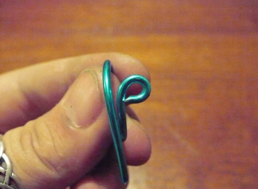 With your round nose pliers make a loop. A good way to do this is pinch lightly and twist the wrist with the pliers while holding the ring steady in the non-dominant hand.