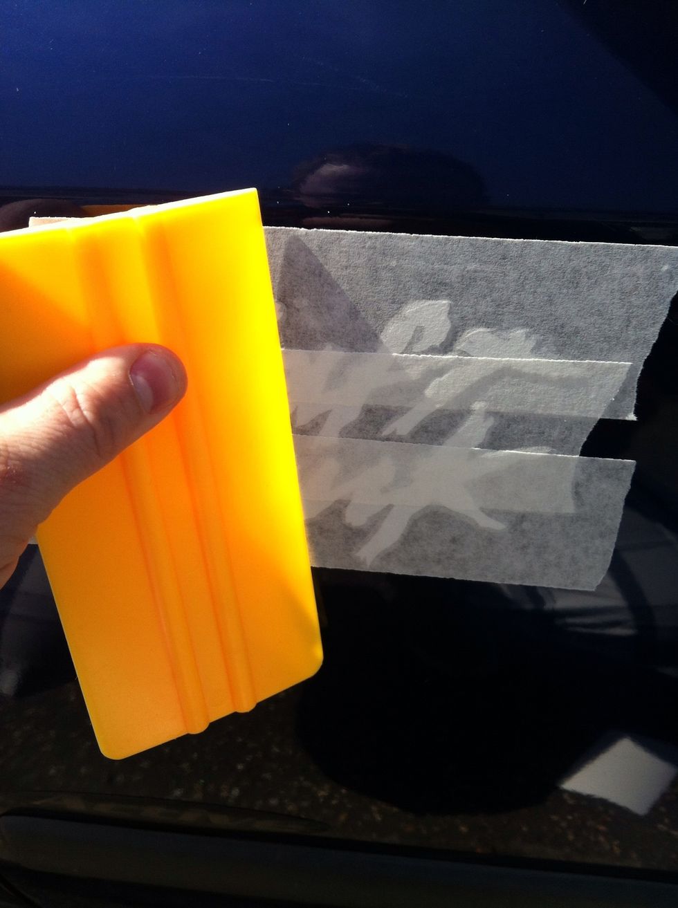 With your squeegee or store/credit card smooth over the decal from top to bottom and from the middle outwards. Make sure all of the decal is smooth on the surface.