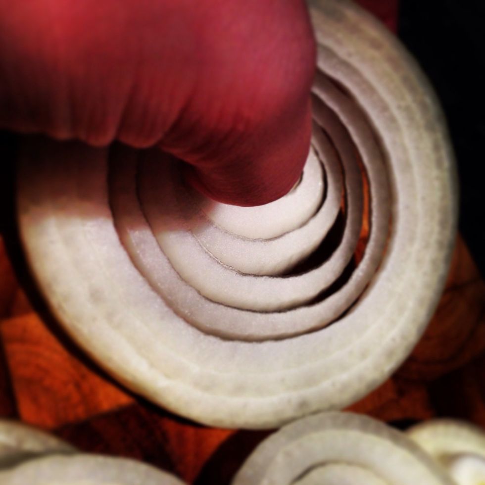 With your thumb push the centre of the onion out to release the rings.
