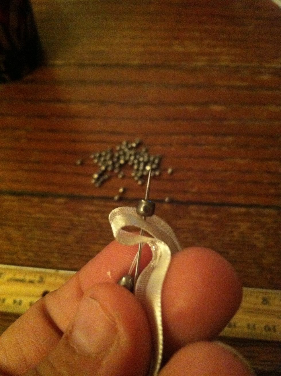 Without pulling the needle through, add another bead.