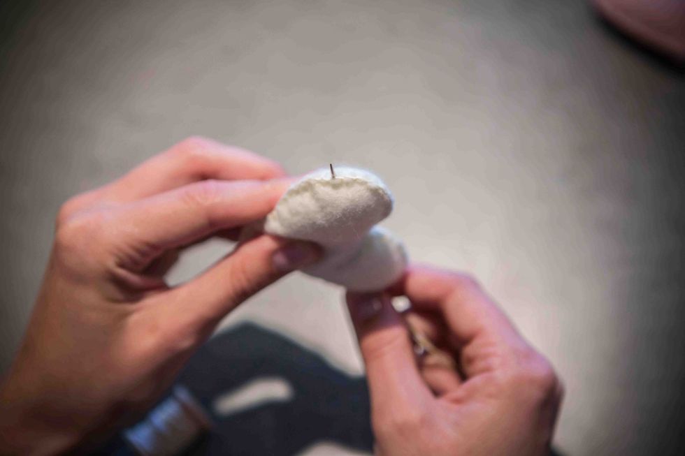 Work the needle through the stuffing to a hole on the other side.