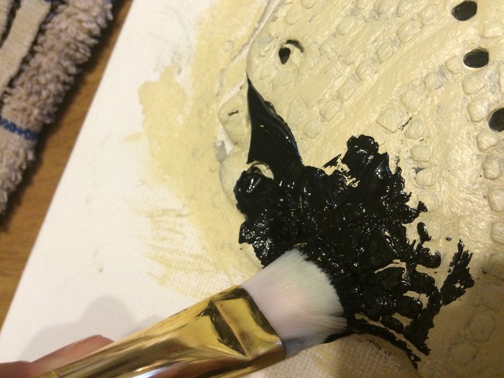 Work the second color paint into the surface of the sculpture with a paint brush.