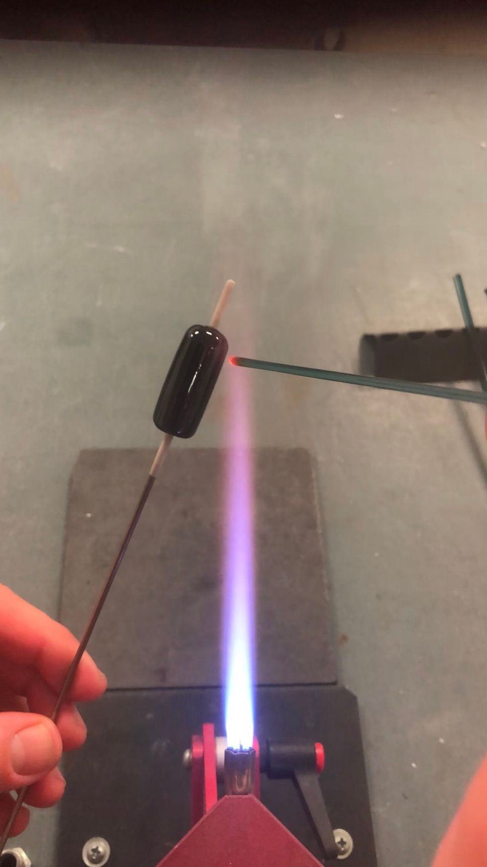 Working in the tip of the flame, begin applying the Melia 2 stringer.