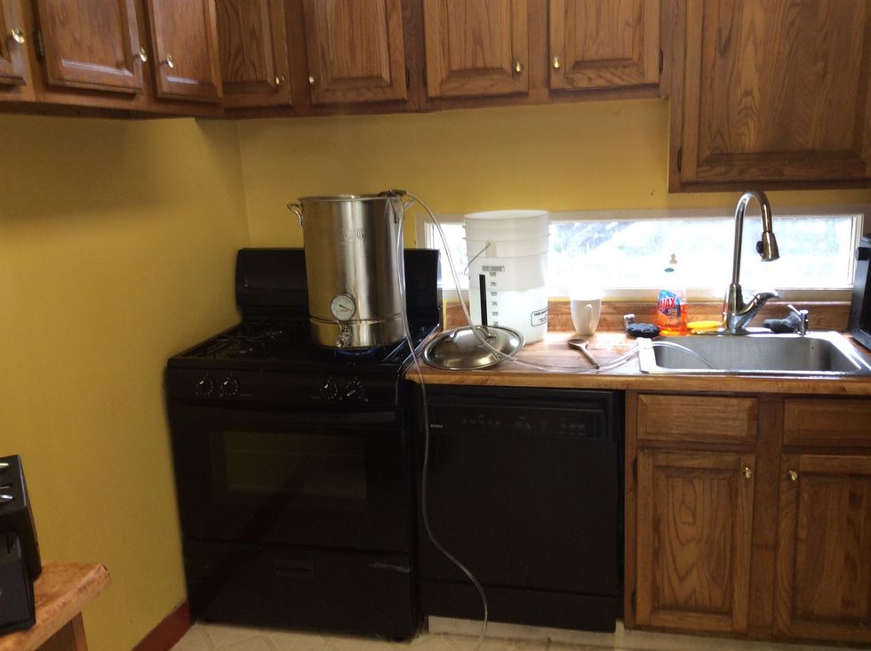 Wort chiller setup. Notice the temperature of the kettle is over 200 deg fahrenheit. The input is attached to my garden hose and output is the sink. Took 15 min to reach 80 degrees.