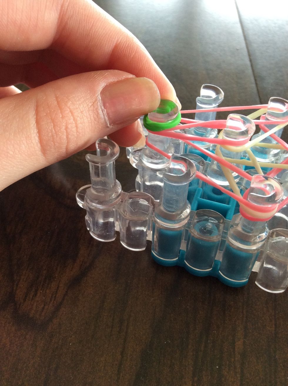 Wrap a green band around the last middle peg, twist into a figure eight, and fold over.