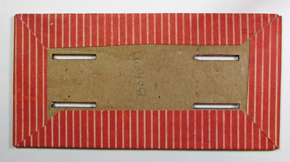 Wrap edges of the base and burnish the paper. Use gel medium to attach the paper to the chipboard surface.