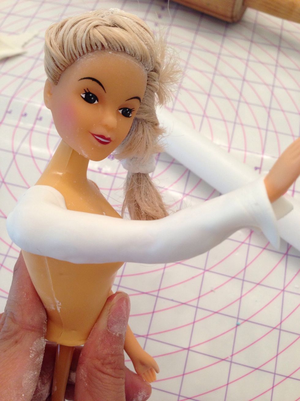 Wrap her arms with white fondant