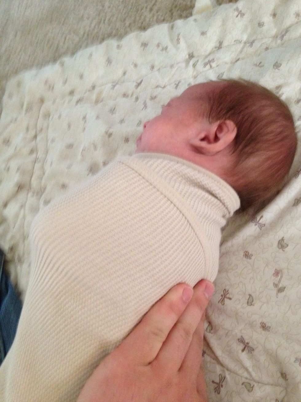 Wrap left side of blanket around the baby and pin under the body also.