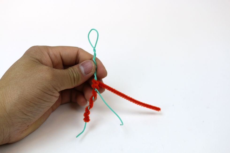 Wrap one end of the pipe cleaner around the hip down to one leg. Use the other end of the pipe cleaner to do the same to the other leg.