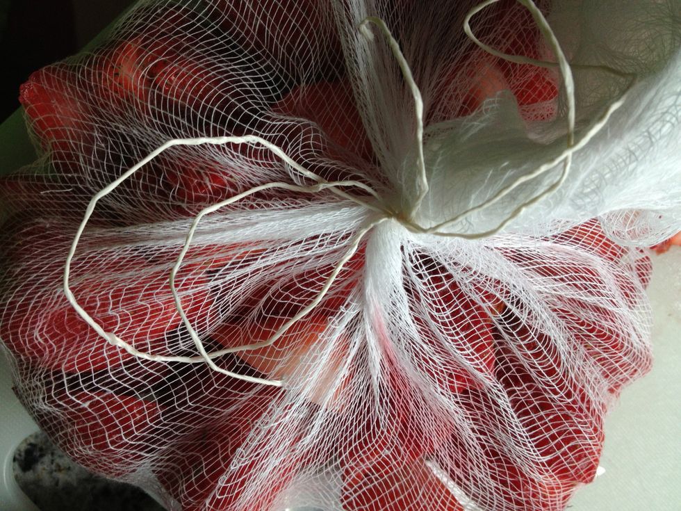 Wrap strawberries in cheese cloth, can double up if you like, and tie with kitchen string.