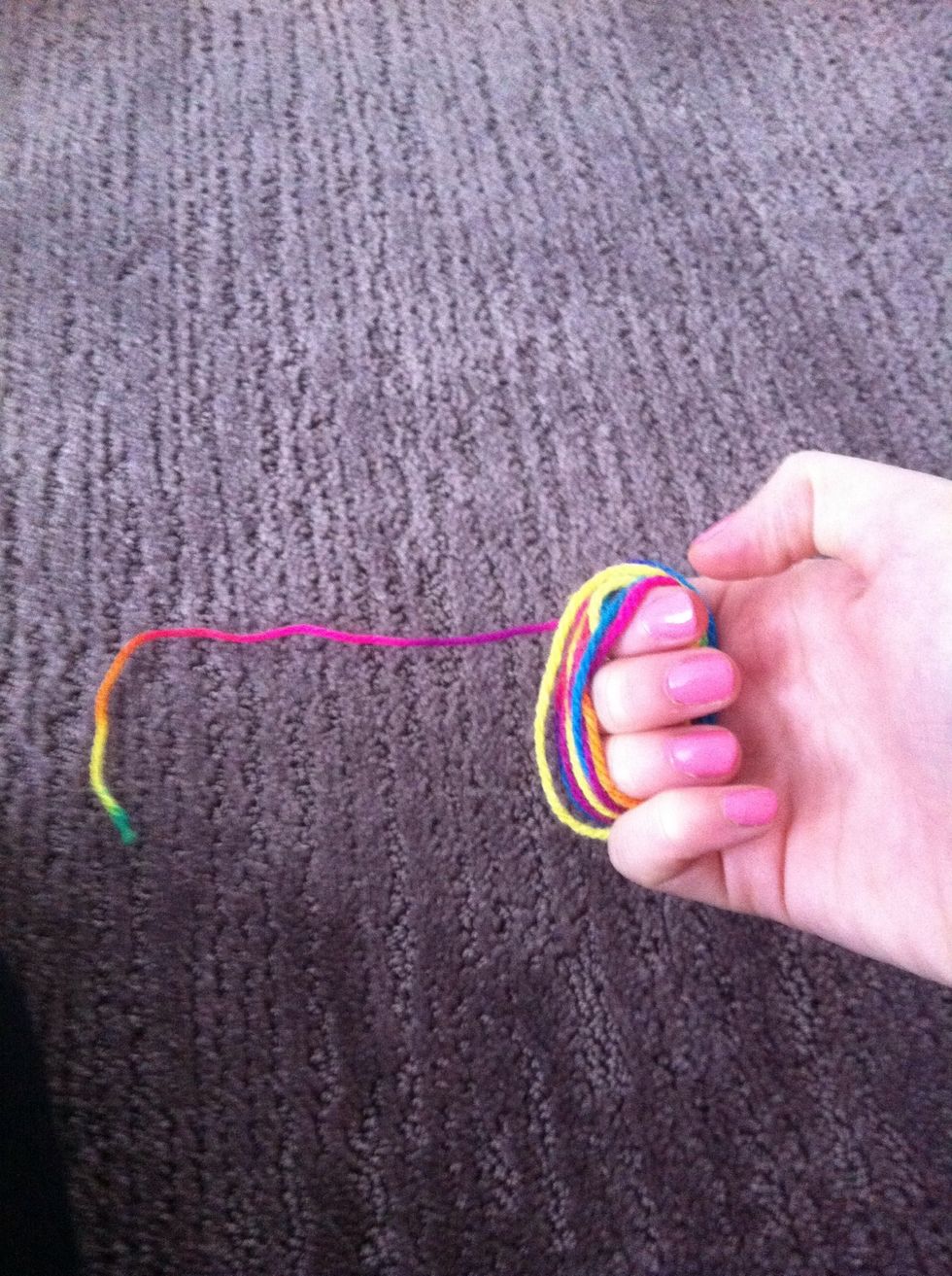 Wrap the cut piece of thread around three fingers leaving some thread.