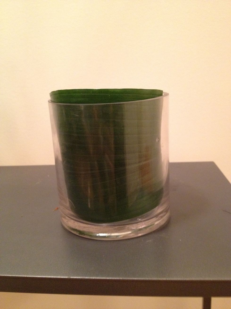 Wrap the leaf inside the vase, so you don't see the stems