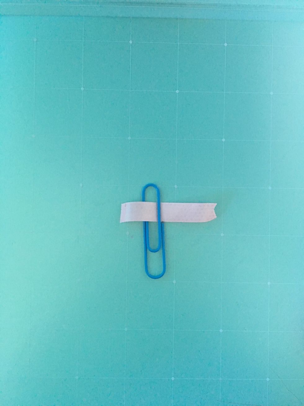 Wrap the piece of tape on the side where the pointy part of the paperclip sticks out.