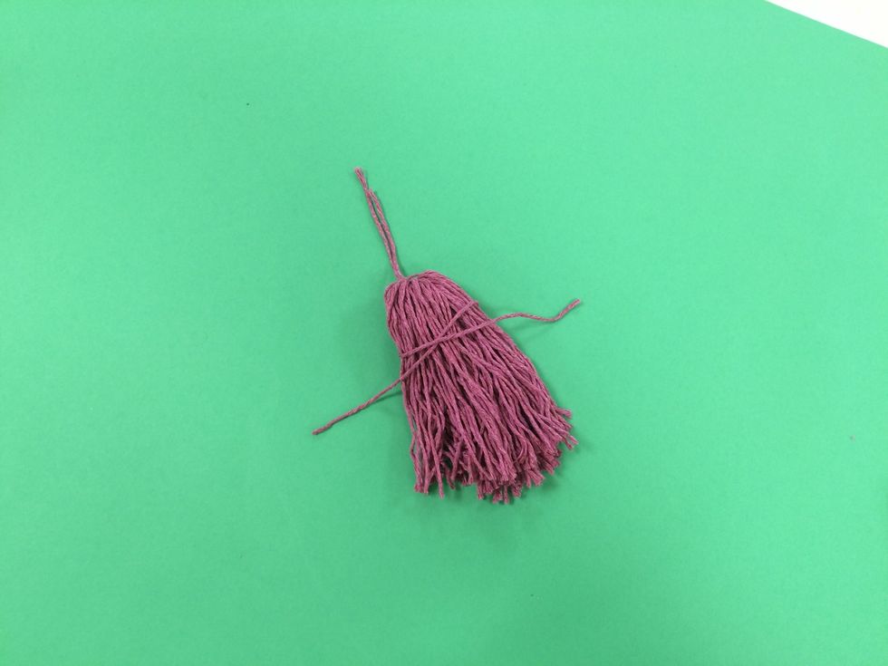 Wrap the piece of yarn around the tassel. You can choose to place it high or low.